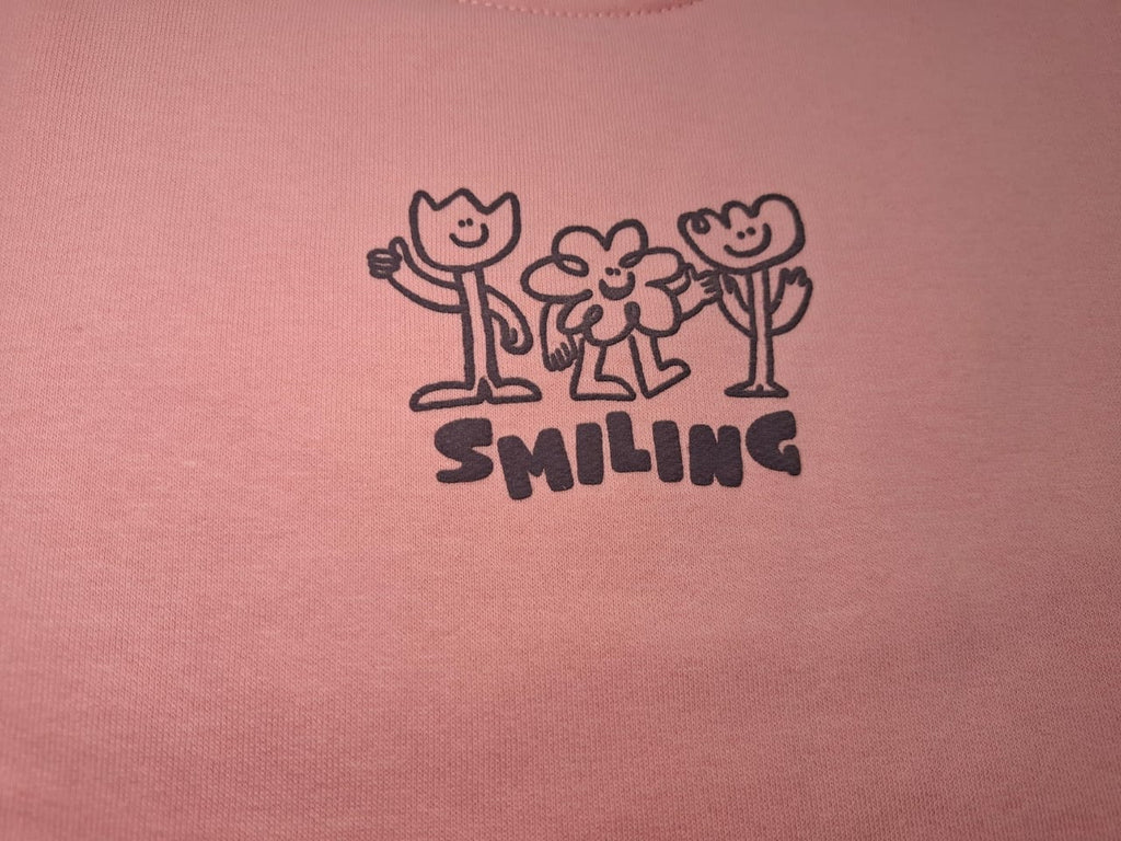 Whisper the Beauty: Pink Sweatshirt with Smiling Flowers Graphic